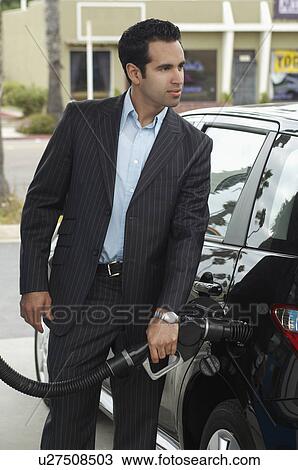 Stock Image - Man filling up van at gas pump. Fotosearch