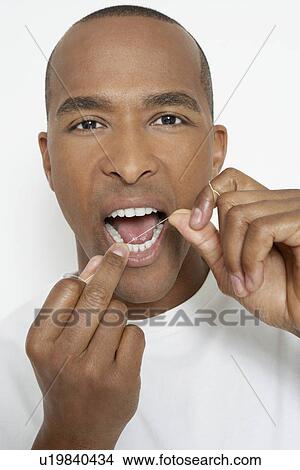 Picture - Man flossing teeth, portrait. Fotosearch