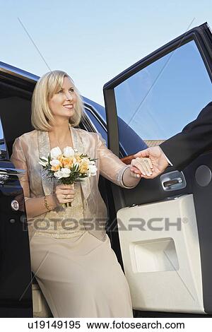 Man helping middle-aged woman from limousine View Large Photo Image Stock Photography - Man helping middle-aged woman from limousine. Fotosearch