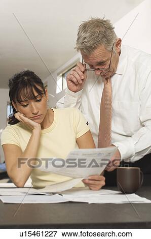 Stock Photo - Man Helping Woman with Bills. Fotosearch