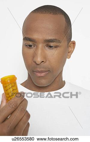 Man holding bottle of pills, studio shot View Large Photo Image Stock Image - Man holding bottle of pills, studio shot. Fotosearch