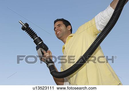 Man holding fuel pump View Large Photo Image Stock Image - Man holding fuel pump. Fotosearch