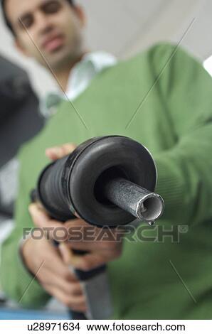 Man holding gas pump, focus on foreground View Large Photo Image Picture - Man holding gas pump, focus on foreground. Fotosearch