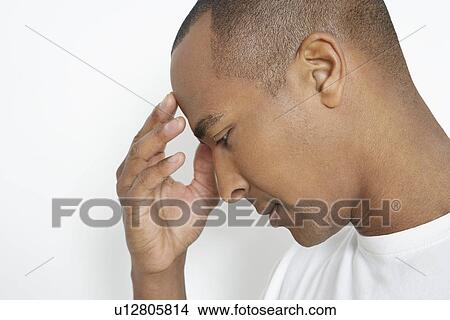 Picture - Man holding head, studio shot. Fotosearch