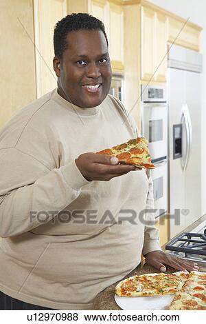 Stock Photo - Man holding slice of pizza. Fotosearch
