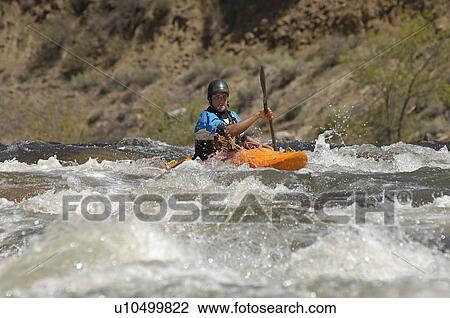 Stock Image - Man kayaking on mountain river. Fotosearch