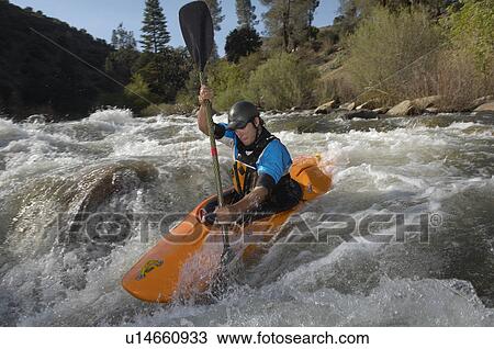 Stock Image - Man kayaking on mountain river. Fotosearch