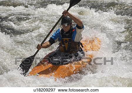 Stock Photo - Man kayaking on mountain river. Fotosearch