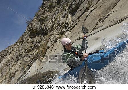 Stock Photograph - Man kayaking on mountain river. Fotosearch