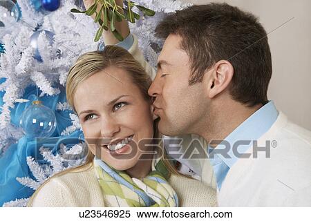 Man kissing woman under mistletoe View Large Photo Image Stock Photography - Man kissing woman under mistletoe. Fotosearch
