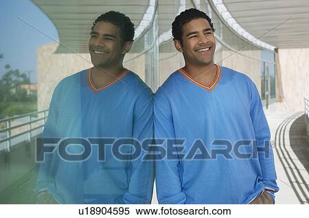 Stock Photography - Man leaning on window, outdoors, portrait. Fotosearch