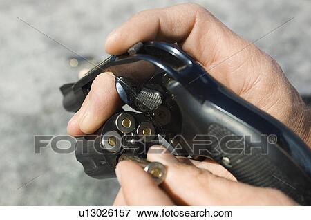 Man loading bullets into gun, close-up of hands View Large Photo Image Stock Photo - Man loading bullets into gun, close-up of hands. Fotosearch