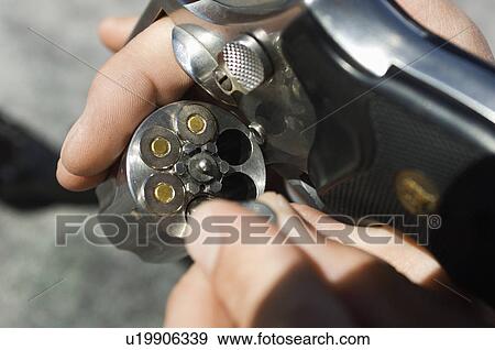 Man loading bullets into gun, close-up of hands View Large Photo Image Stock Photo - Man loading bullets into gun, close-up of hands. Fotosearch