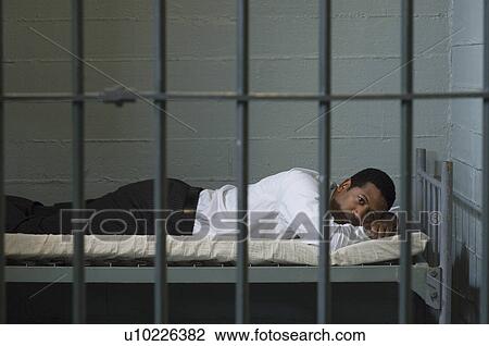 Man lying in prison cell View Large Photo Image Stock Image - Man lying in prison cell. Fotosearch