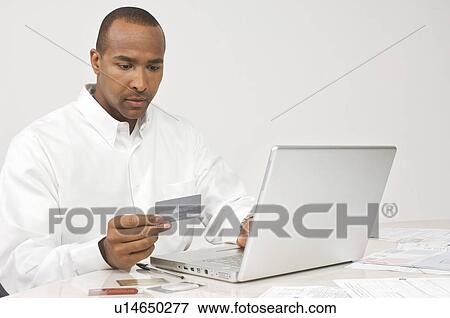 Stock Photo - Man Making Online Transaction. Fotosearch