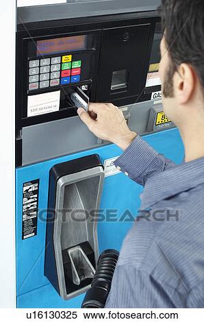 Stock Photography - Man paying with credit card at fuel pump. Fotosearch