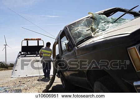Man preparing to lift crashed car onto tow truck View Large Photo Image Stock Image - Man preparing to lift crashed car onto tow truck. Fotosearch