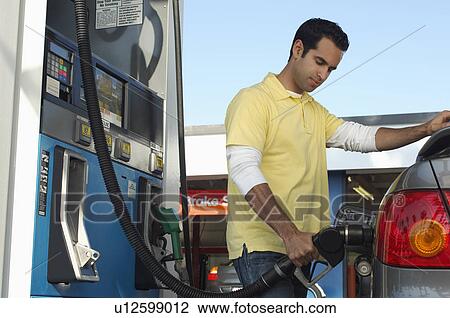 Stock Image - Man pumping gas. Fotosearch
