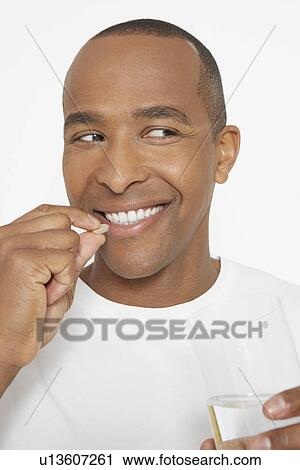 Man taking pills, holding glass of water, portrait View Large Photo Image Stock Image - Man taking pills, holding glass of water, portrait. Fotosearch
