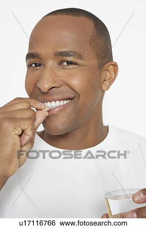 Man taking pills, holding glass of water, portrait View Large Photo Image Stock Photograph - Man taking pills, holding glass of water, portrait. Fotosearch