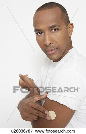 Stock Photo - Man with patch on arm, portrait. Fotosearch