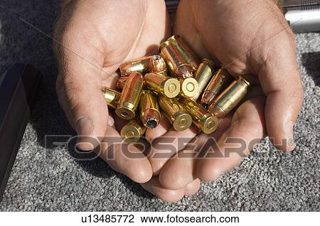 Mans hands holding bullets, close-up View Large Photo Image Stock Image - Mans hands holding bullets, close-up. Fotosearch