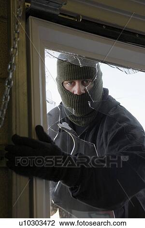 Masked thief braking in through window View Large Photo Image Stock Image - Masked thief braking in through window. Fotosearch