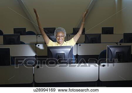 Mature female student celebrating in computer classroom View Large Photo Image Stock Photo - Mature female student celebrating in computer classroom. Fotosearch