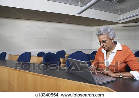 Mature female student using laptop in lecture theatre View Large Photo Image Picture - Mature female student using laptop in lecture theatre. Fotosearch