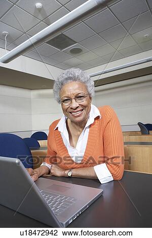 Mature female student using laptop in lecture theatre, portrait View Large Photo Image Stock Image - Mature female student using laptop in lecture theatre, portrait. Fotosearch