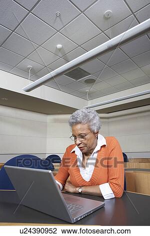 Mature female student using laptop in lecture theatre View Large Photo Image Stock Image - Mature female student using laptop in lecture theatre. Fotosearch