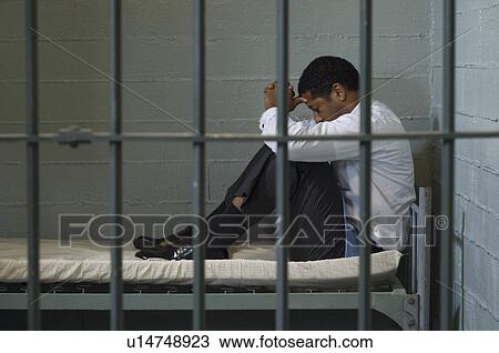 Mature man sitting on bed in prison cell View Large Photo Image Stock Image - Mature man sitting on bed in prison cell. Fotosearch