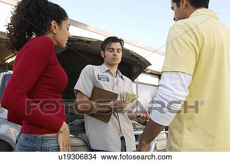 Mechanic counting money by couple View Large Photo Image Picture - Mechanic counting money by couple. Fotosearch