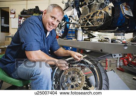 Picture - Mechanic Working on a Tire. Fotosearch