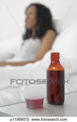 Medicine on bedside table beside woman in bed View Large Photo Image Stock Image - Medicine on bedside table beside woman in bed. Fotosearch