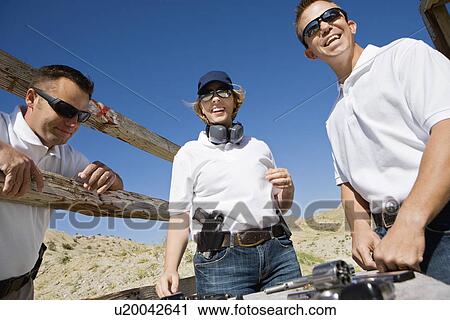 Men and woman with hand guns at firing range View Large Photo Image Stock Image - Men and woman with hand guns at firing range. Fotosearch