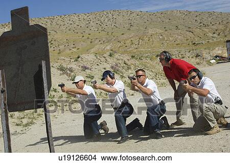 Men firing guns at shooting range View Large Photo Image Picture - Men firing guns at shooting range. Fotosearch