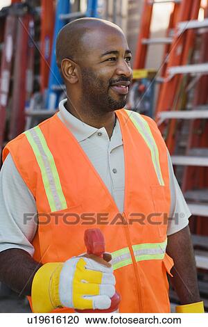 Stock Image - Mid-adult construction worker at work. Fotosearch