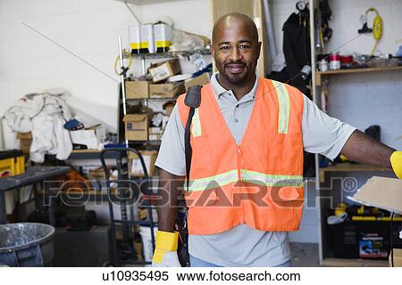 Stock Photography - Mid-adult construction worker preparing to work. Fotosearch