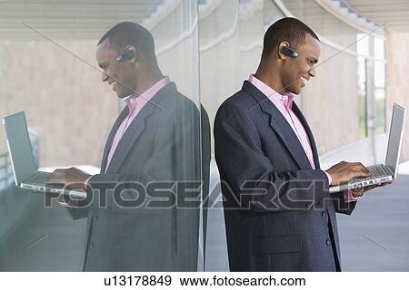 Mid adult man using laptop outdoors View Large Photo Image Stock Photo - Mid adult man using laptop outdoors. Fotosearch