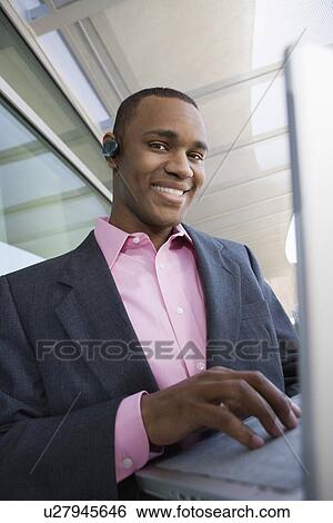 Mid adult man using laptop outdoors, portrait View Large Photo Image Stock Photograph - Mid adult man using laptop outdoors, portrait. Fotosearch