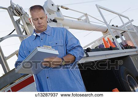 Stock Photo - Mid-adult mechanic at work. Fotosearch