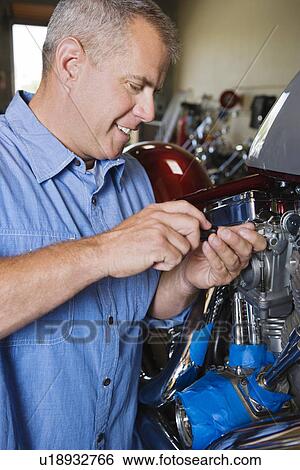 Mid-adult mechanic at work View Large Photo Image Stock Photograph - Mid-adult mechanic at work. Fotosearch