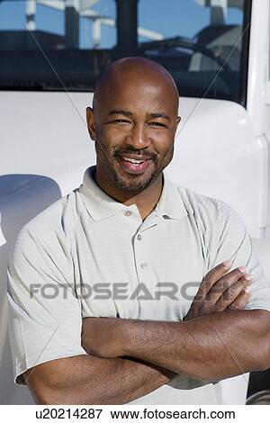 Mid-adult truck driver in front of a truck View Large Photo Image Stock Photo - Mid-adult truck driver in front of a truck. Fotosearch