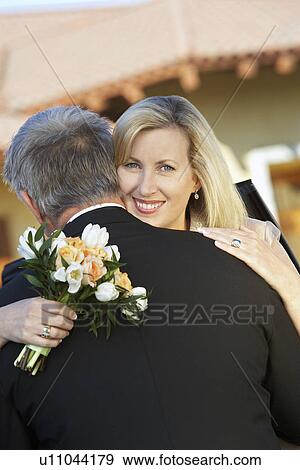Stock Photo - Middle-aged woman embracing man. Fotosearch
