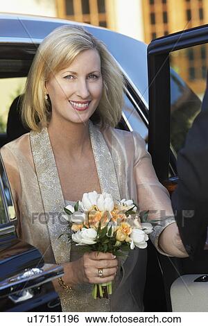 Middle-aged woman holding bouquet in open door of limousine, portrait View Large Photo Image Stock Photograph - Middle-aged woman holding bouquet in open door of limousine, portrait. Fotosearch