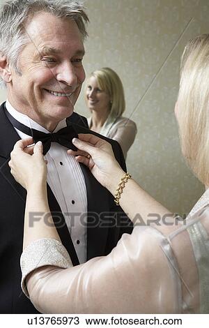 Middle-aged woman tying husband's bow tie View Large Photo Image Stock Image - Middle-aged woman tying husband's bow tie. Fotosearch