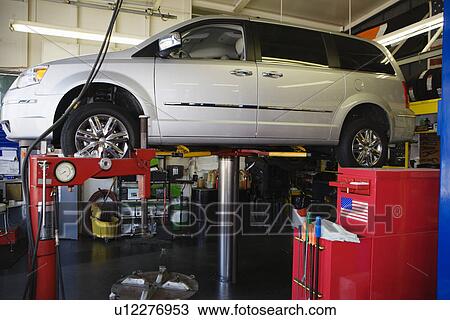 Stock Image - Minivan on a Lift in Shop. Fotosearch