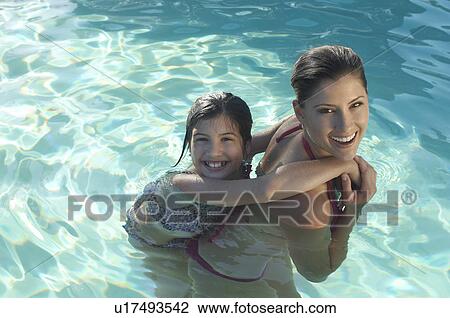Mother giving daughter piggy back in swimming pool, portrait View Large Photo Image Stock Image - Mother giving daughter piggy back in swimming pool, portrait. Fotosearch