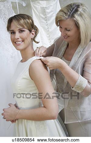 Mother helping daughter to dress View Large Photo Image Picture - Mother helping daughter to dress. Fotosearch